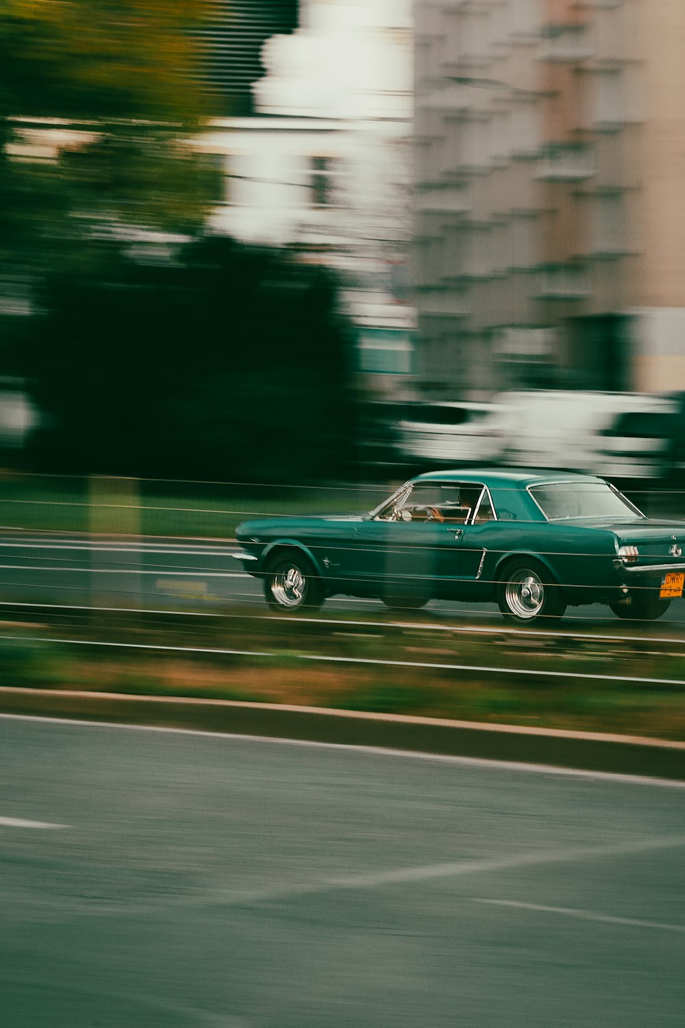 a green car driving down a road