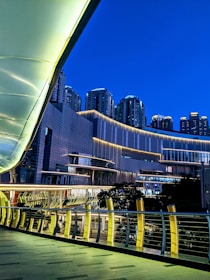 Photo of a well-lit pedestrian walkway in Canary Wharf during the evening.