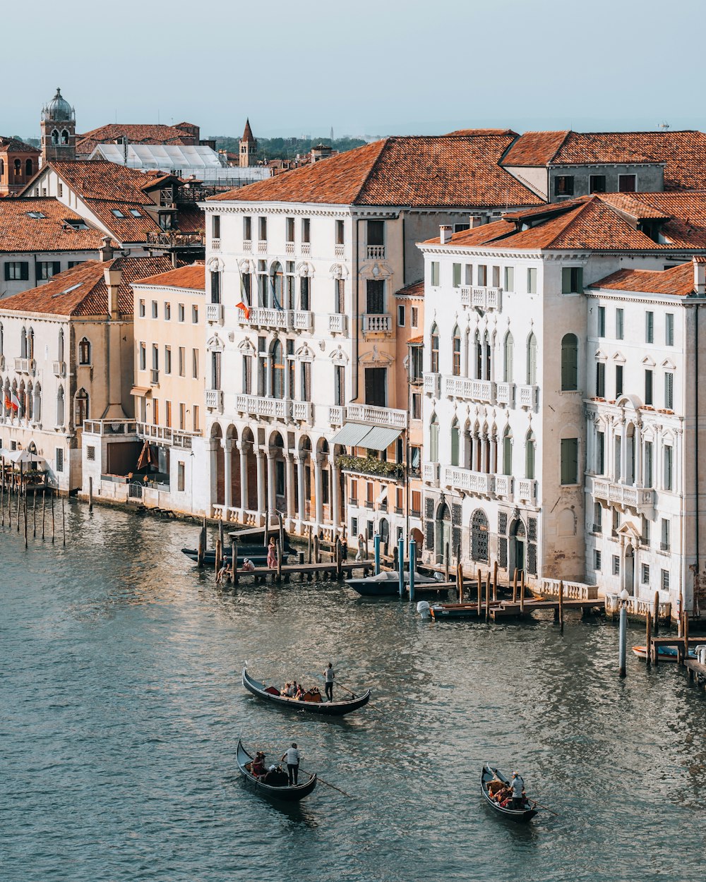 eine Gruppe von Booten in einem Kanal mit Canal Grande im Hintergrund