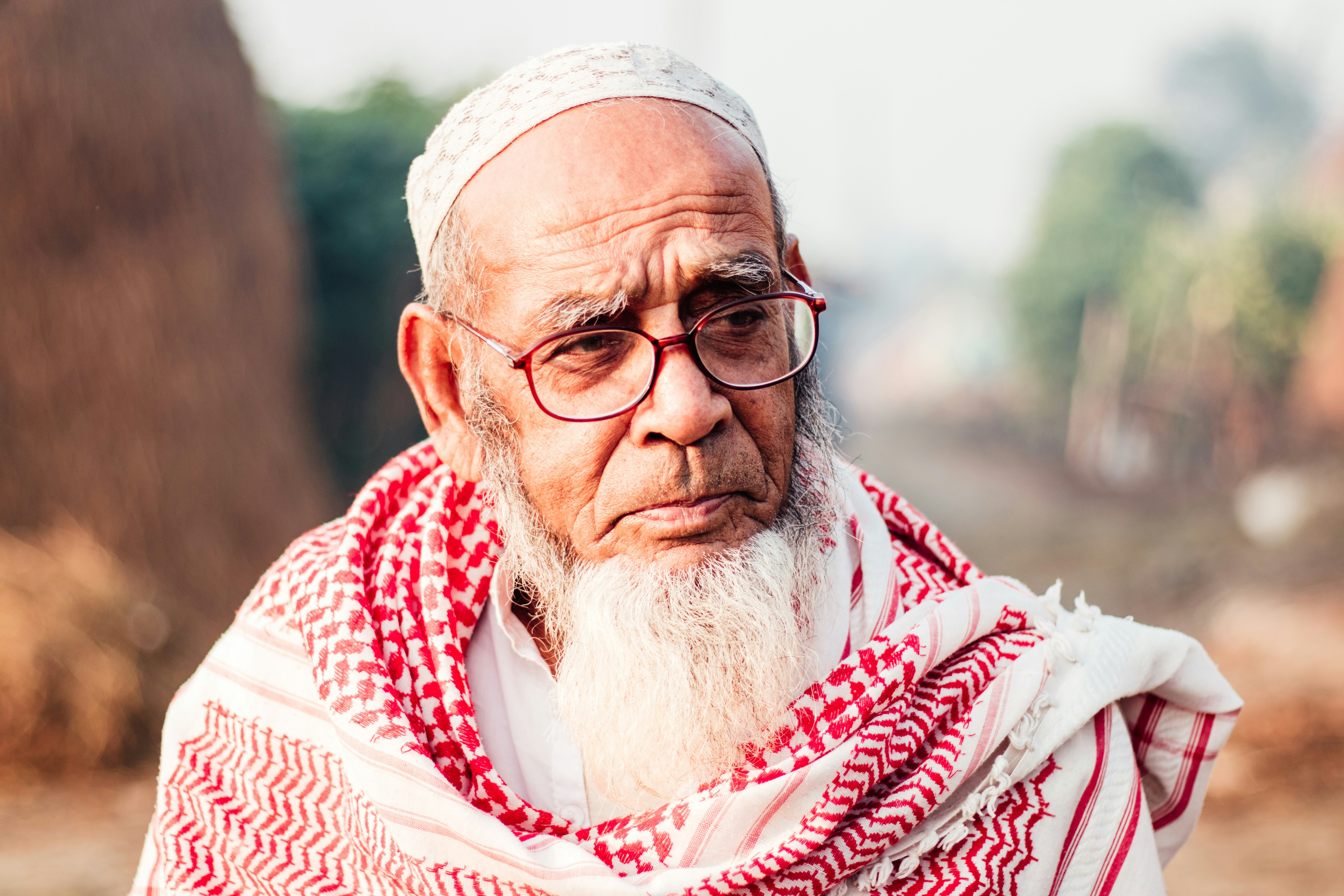 An elderly person sitting alone on a park bench.