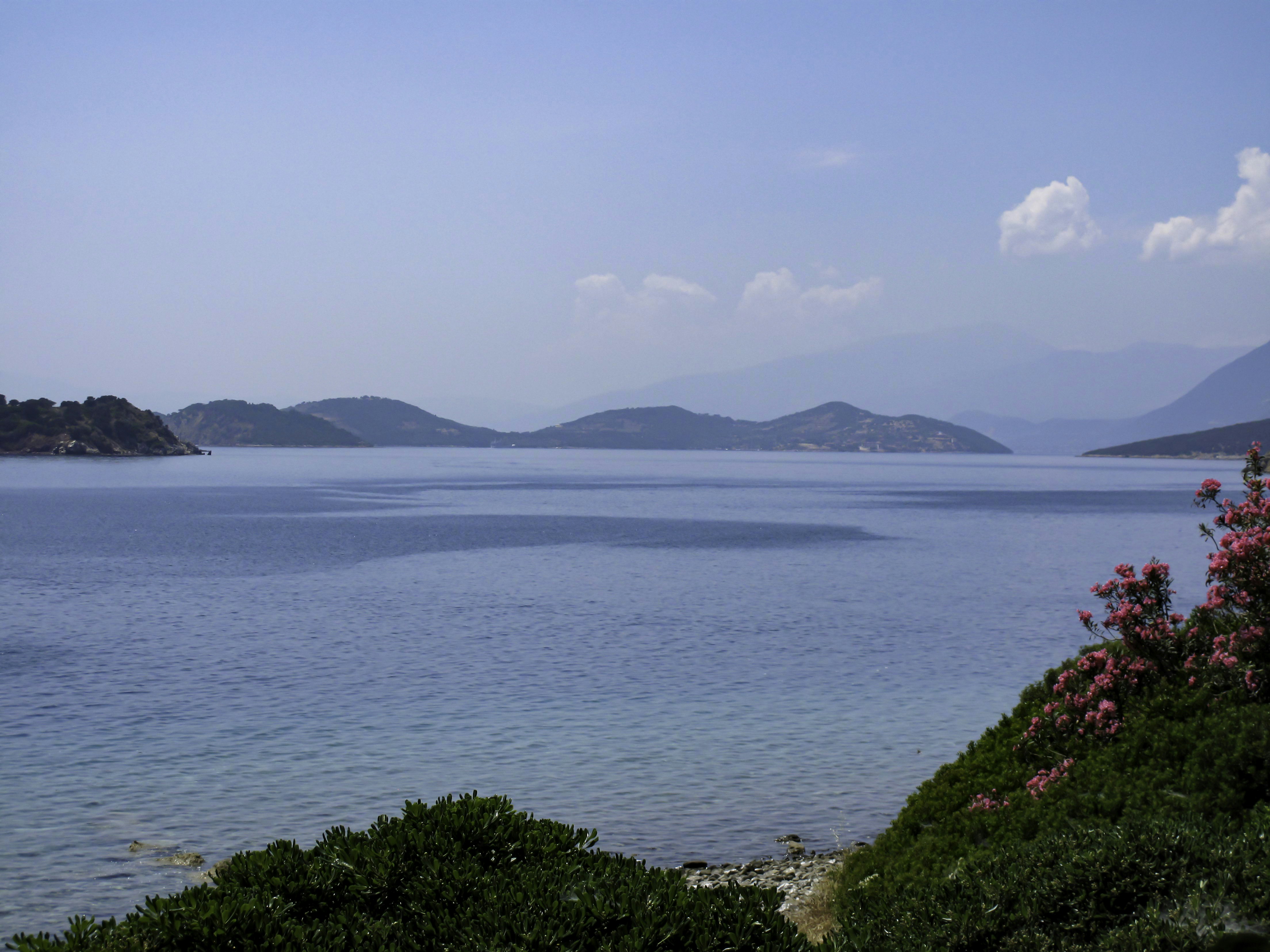 a body of water with hills in the background, 