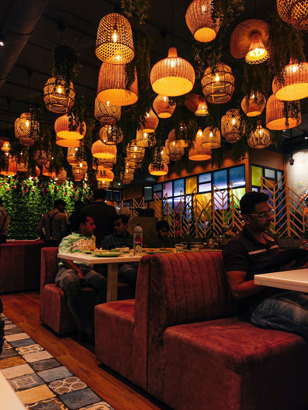 people sitting at tables under chandeliers