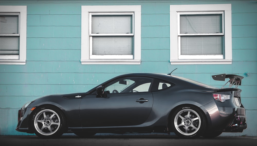 a black car parked in front of a blue building