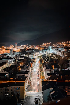A nighttime cityscape of Carlisle with car headlights illuminating the streets.