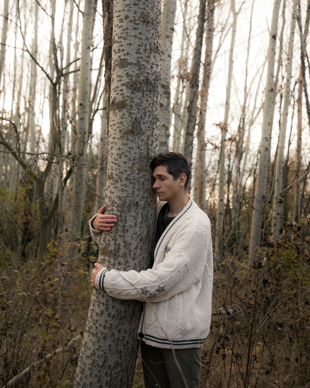 una persona parada junto a un árbol