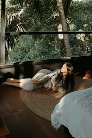 A serene spa room bathed in warm natural light with tropical plants and soft linens.