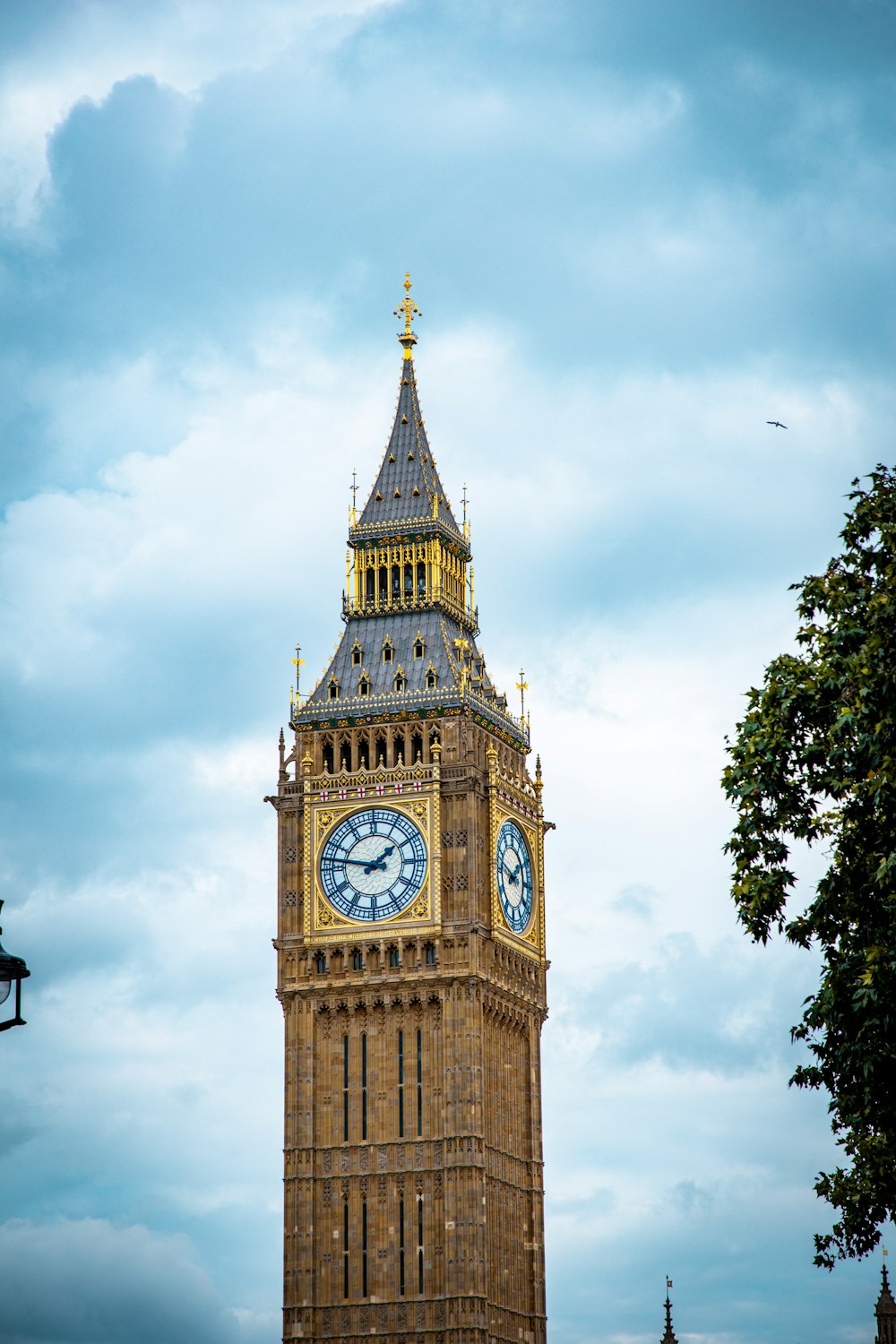 una torre dell'orologio con una banderuola con il Big Ben sullo sfondo