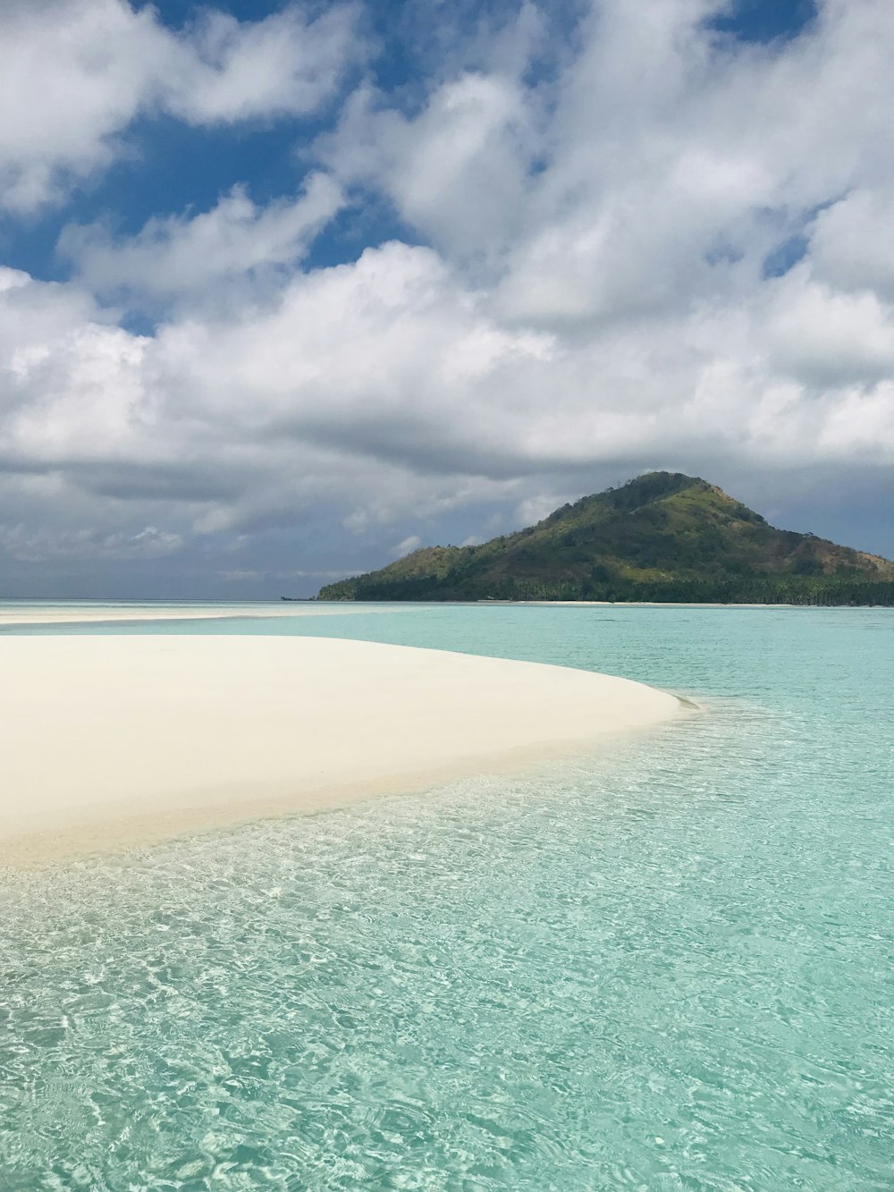 a beach with a hill in the background