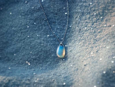 a blue pendant on a chain