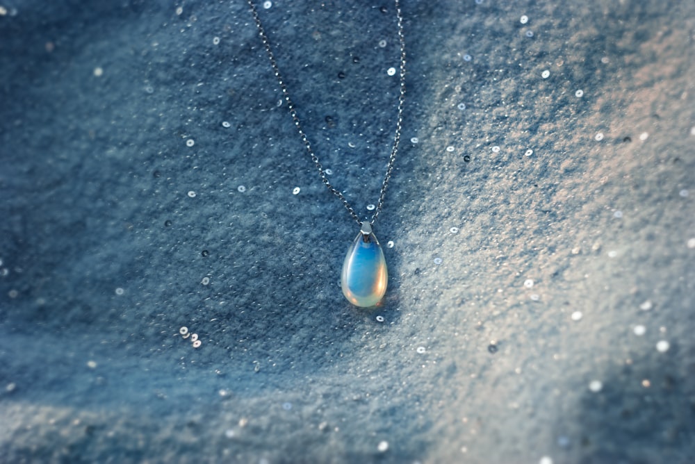 a blue pendant on a chain