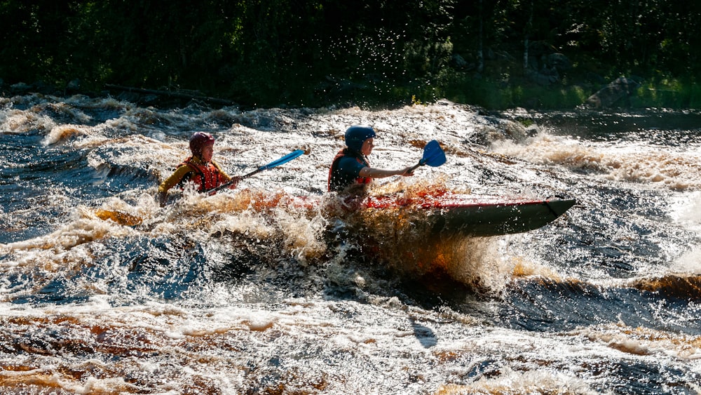 a group of people paddle a canoe down a river