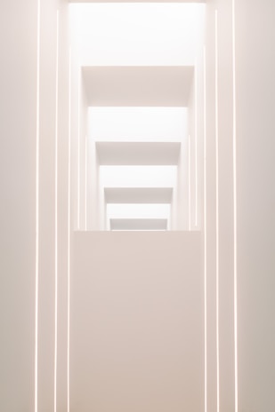 A sleek, minimalistic architectural structure bathed in soft futuristic lighting.