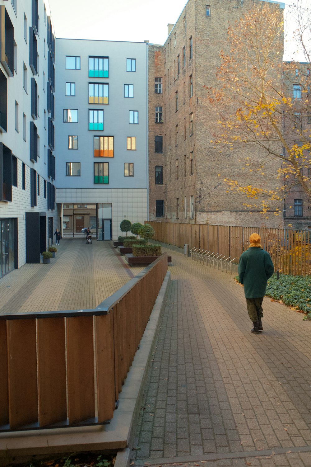 a person walking on a brick path between buildings