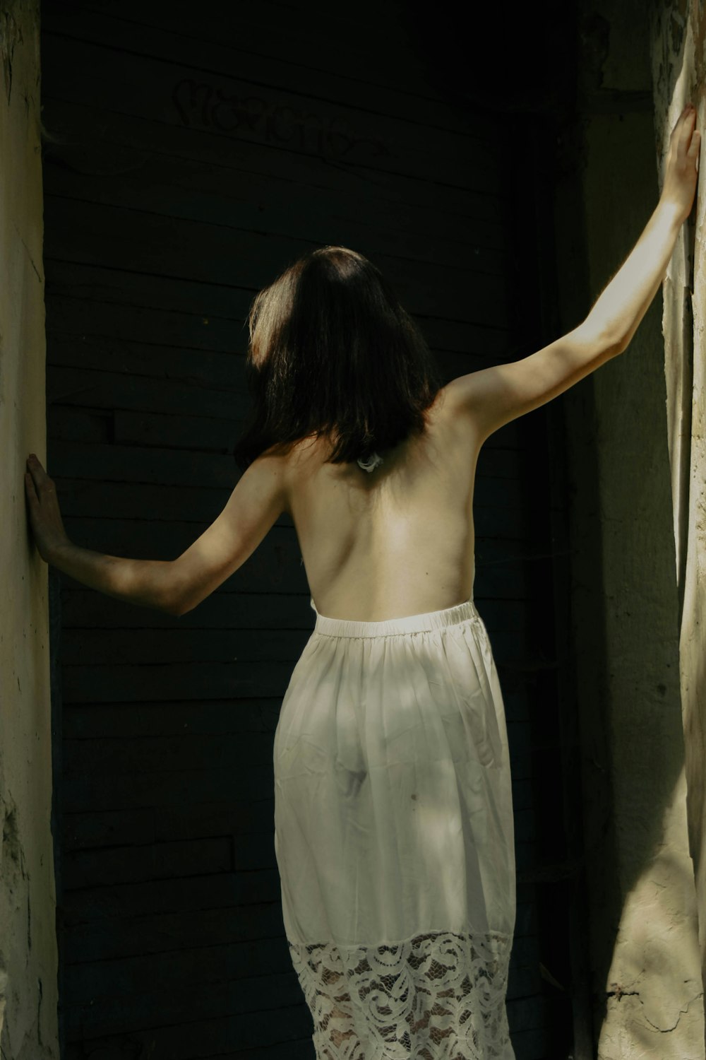 a woman standing in front of a wooden wall