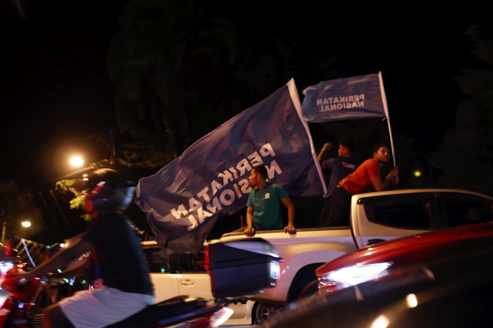 a group of people standing around a car with a tent on top