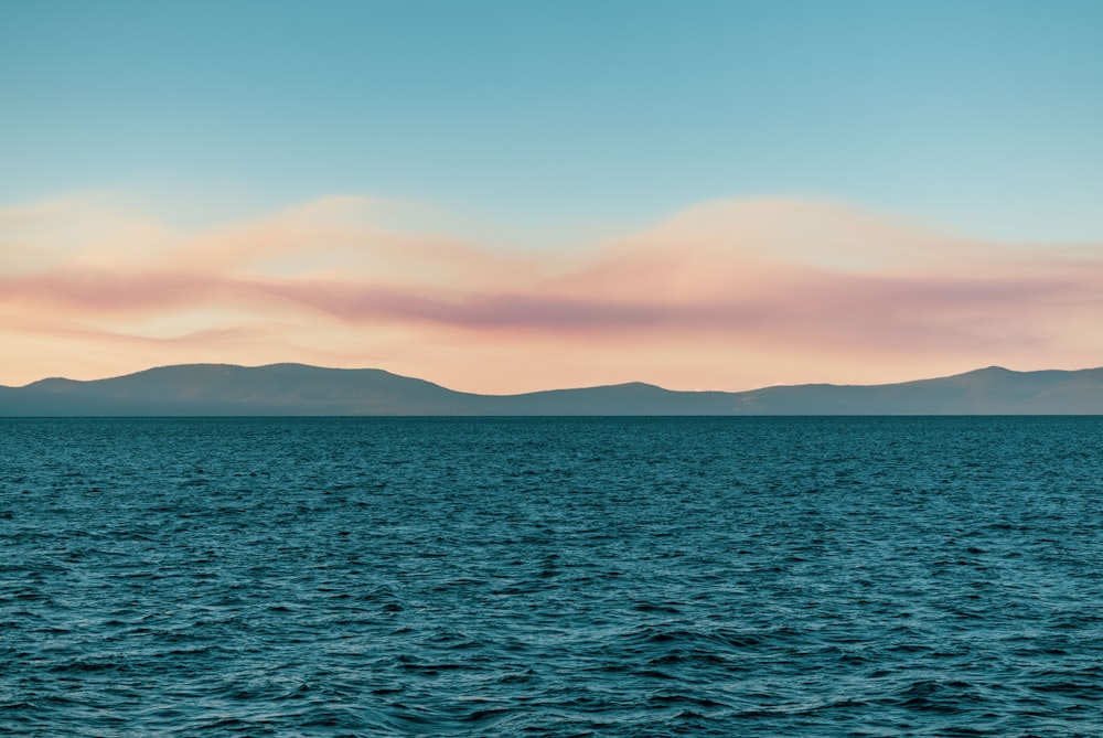 a body of water with mountains in the background