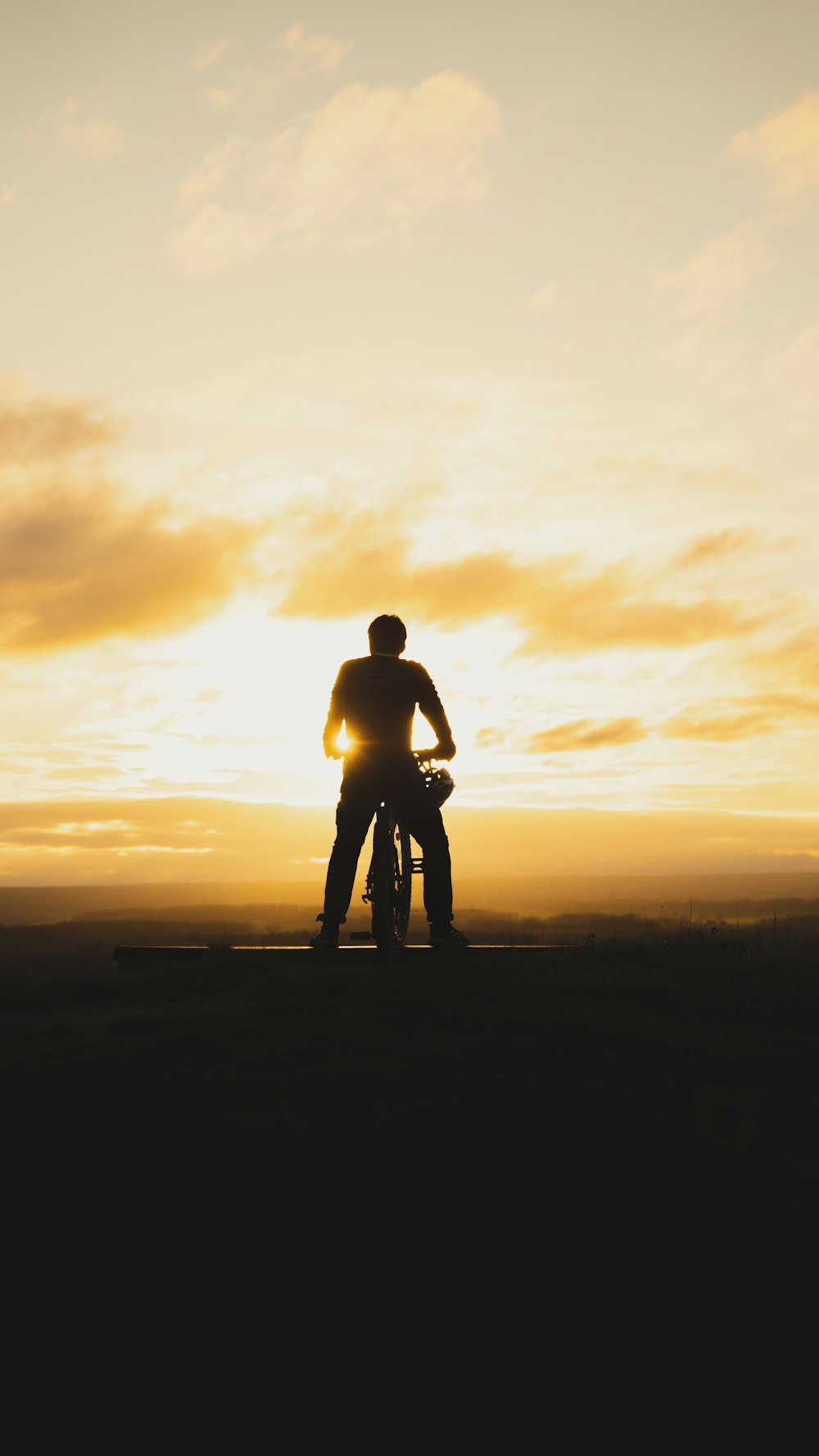 a man and a woman standing in front of a sunset