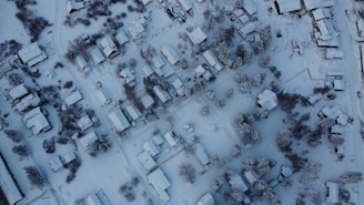 A panoramic view of a neighborhood blanketed in snow with clear paths.