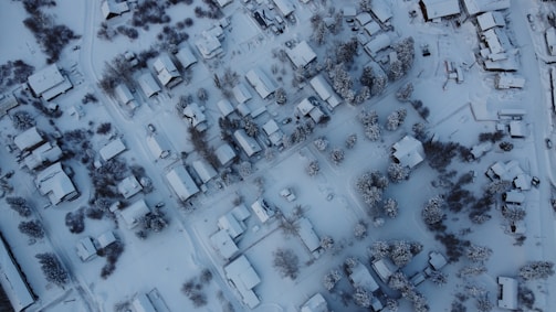 A panoramic view of a neighborhood blanketed in snow with clear paths.