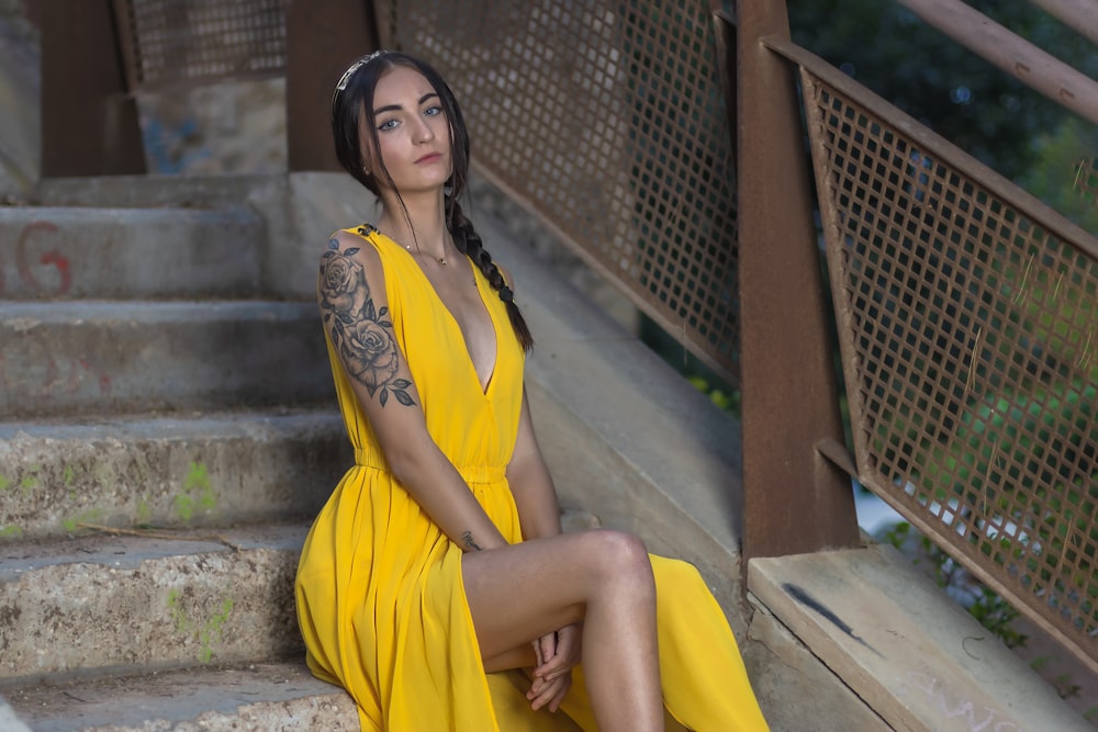 a person in a yellow dress sitting on stairs