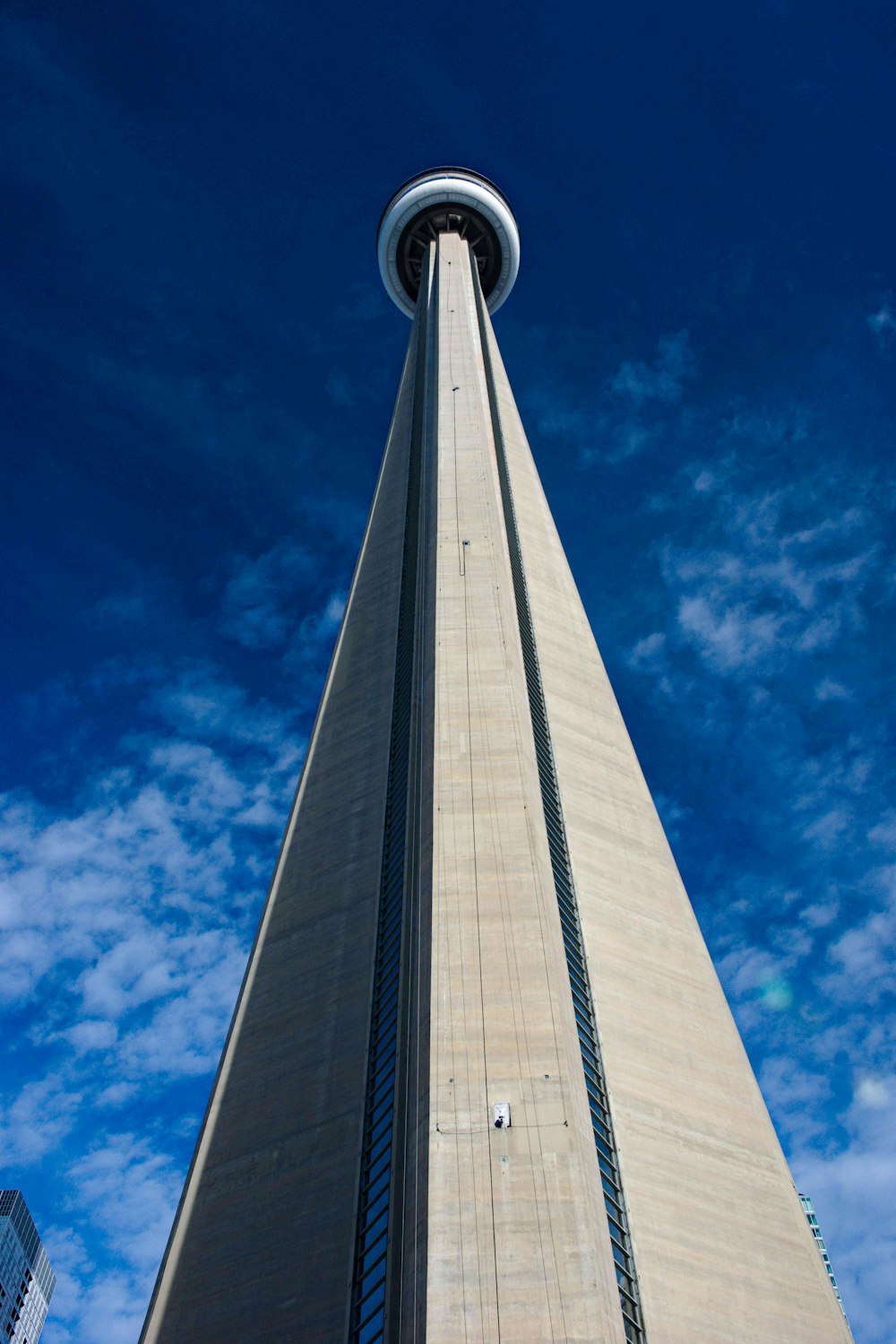 a tall tower with a round top with CN Tower in the background