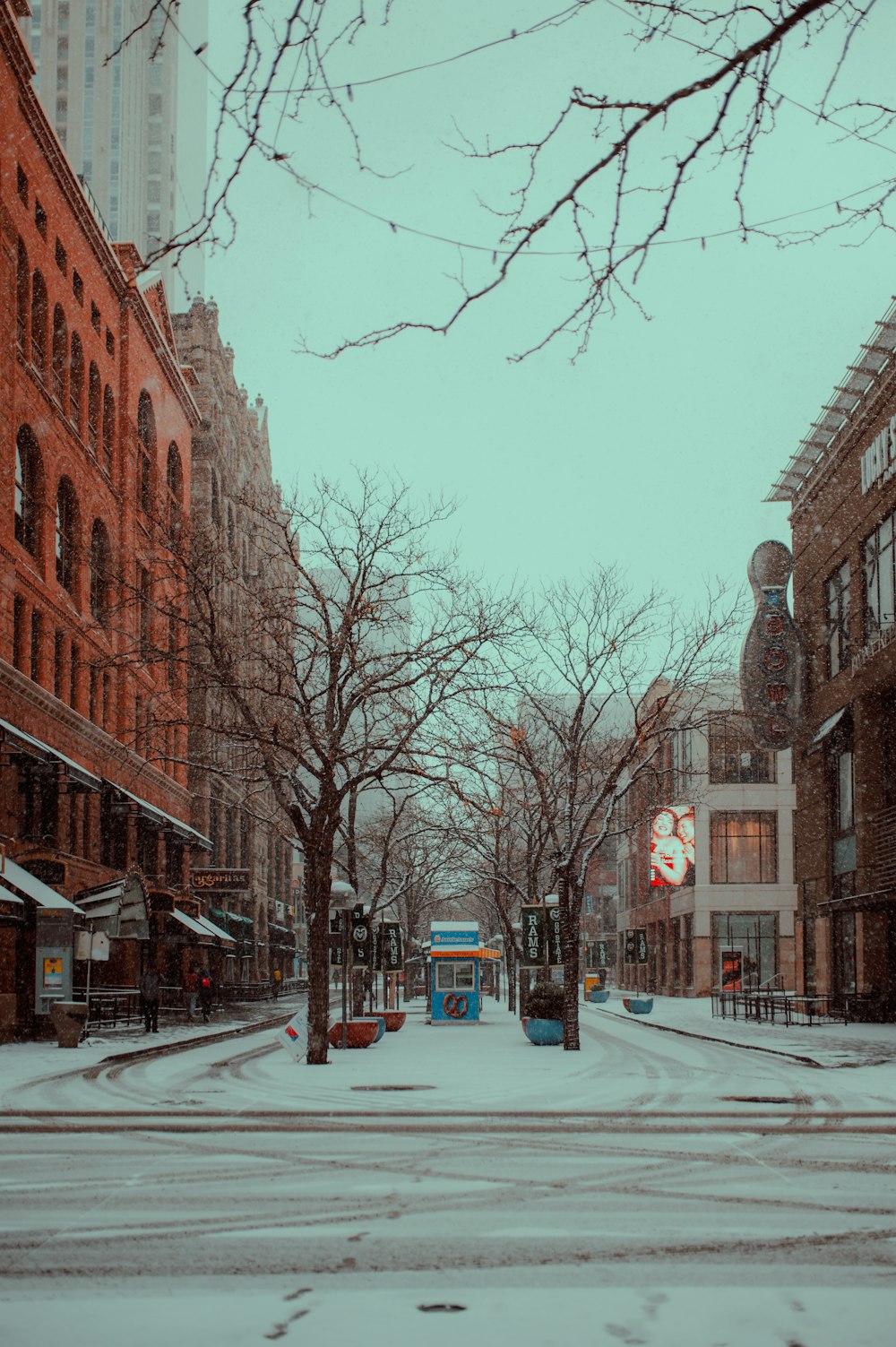 a snowy street with buildings on either side of it