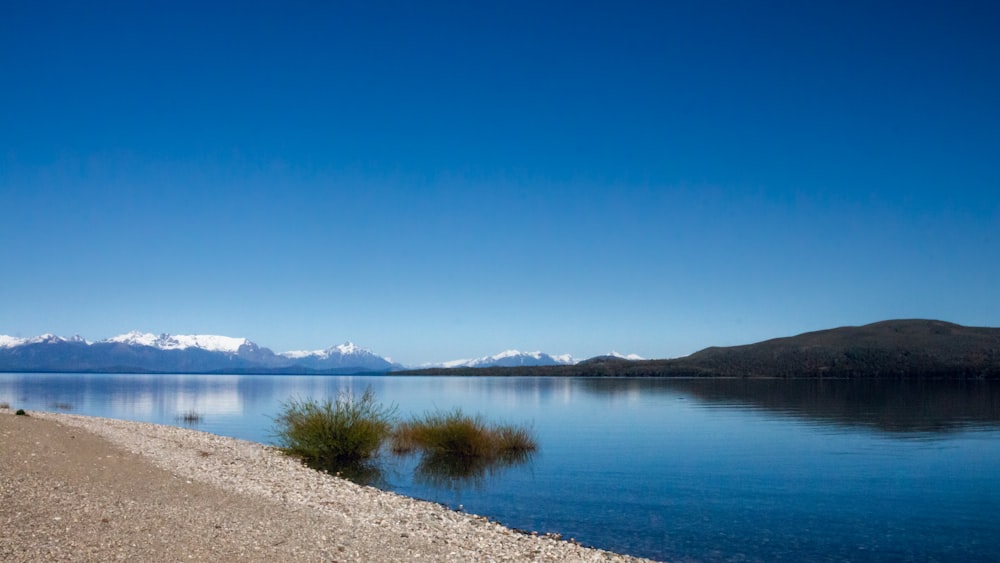 a body of water with mountains in the background