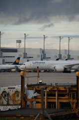 A vibrant scene of planes lined up at Munich Airport with enthusiasts watching and photographing.