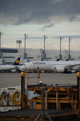 A vibrant scene of planes lined up at Munich Airport with enthusiasts watching and photographing.