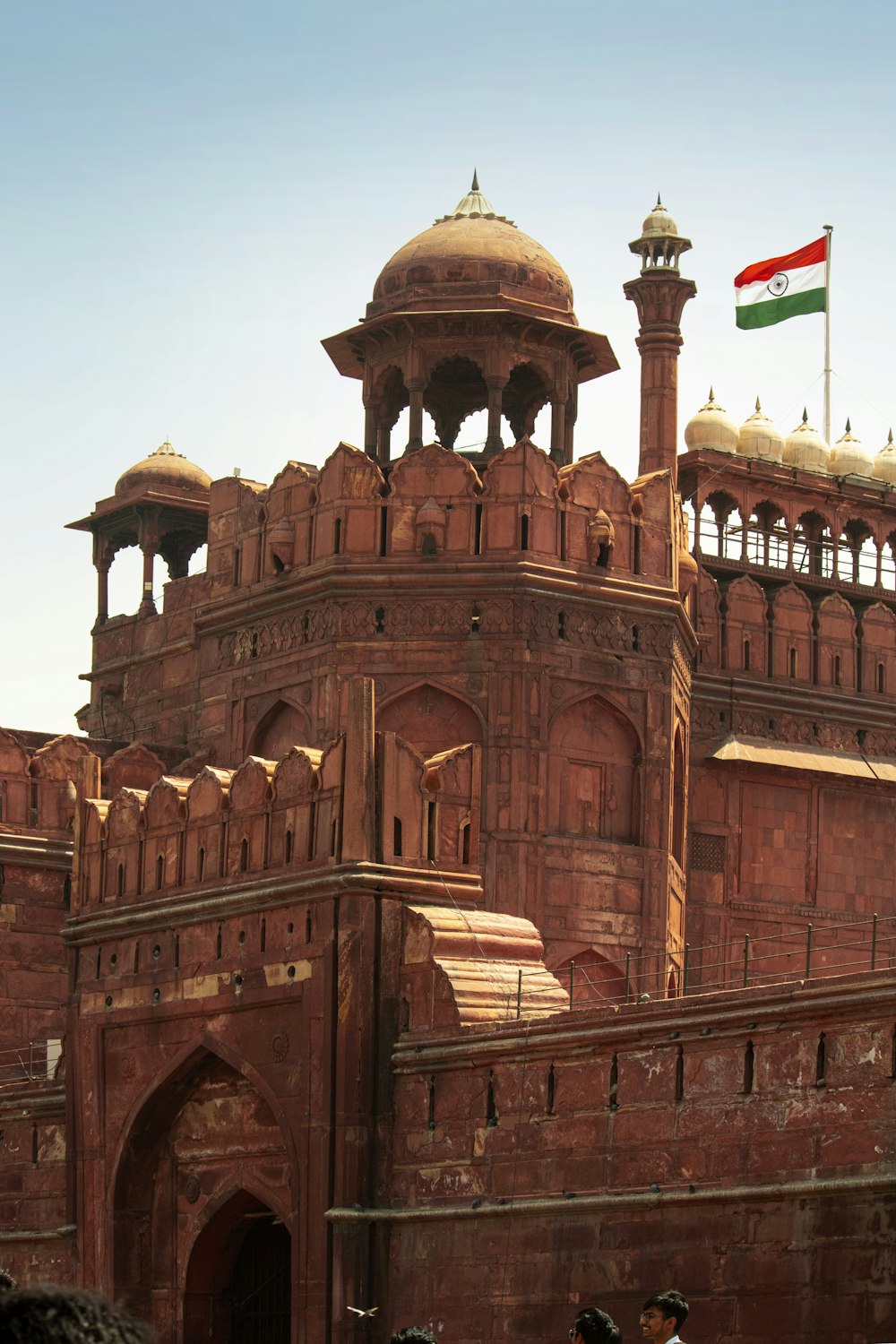 a large building with a flag on top with Red Fort in the background