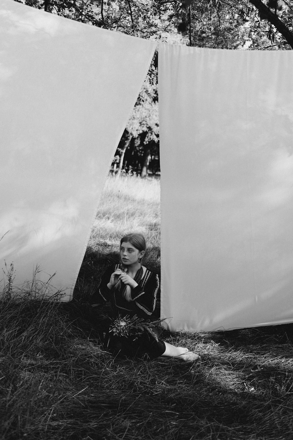 a boy sitting next to a large white tent