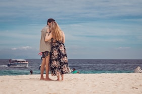 a man and woman kissing on a beach