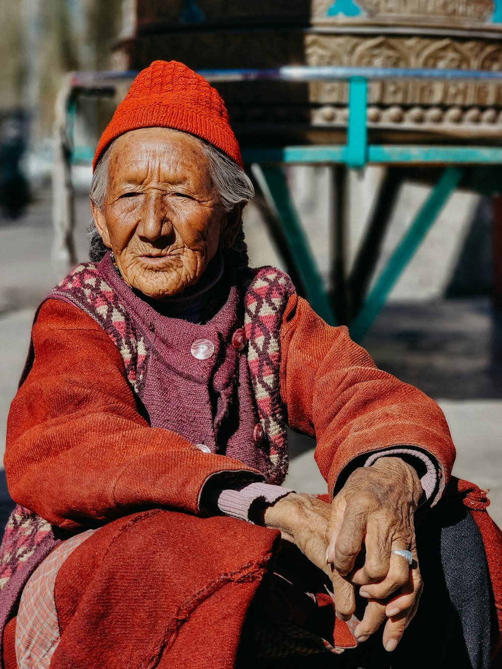 Un vecchio con una sciarpa rossa e un cappello rosso