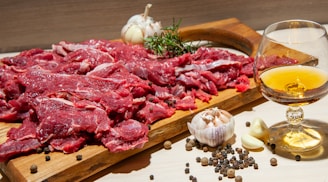 a board with raw meat and a glass of wine