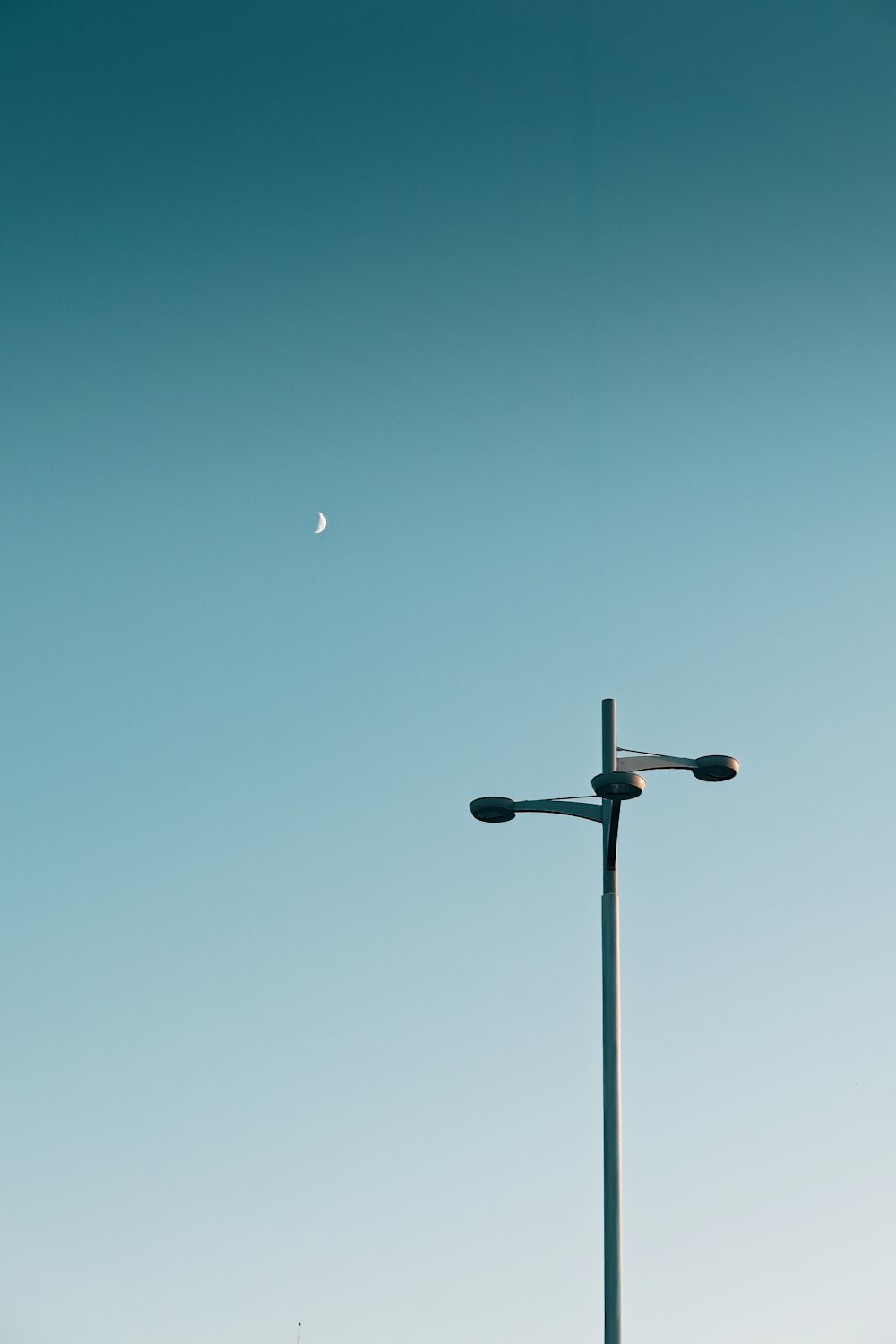a street light with a moon in the background