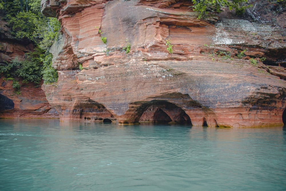 una grande formazione rocciosa accanto a uno specchio d'acqua