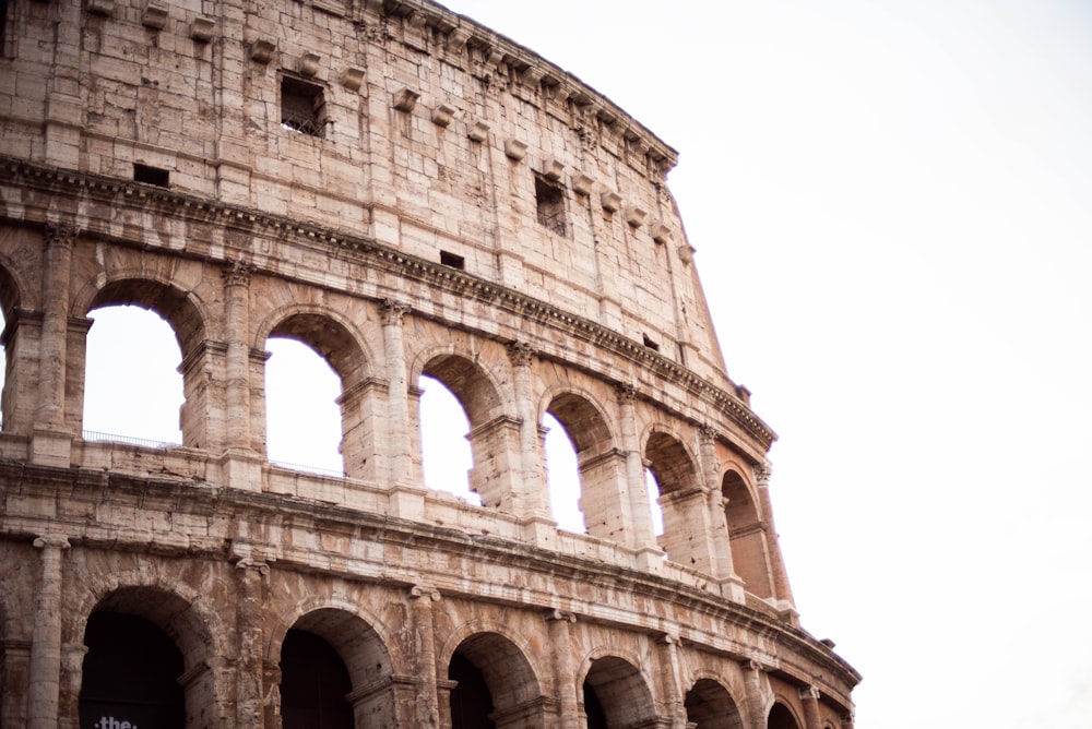 a large stone building with Colosseum in the background