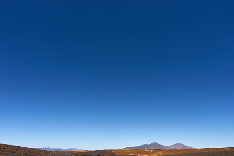 A striking photo of a flat horizon stretching endlessly under a clear blue sky.