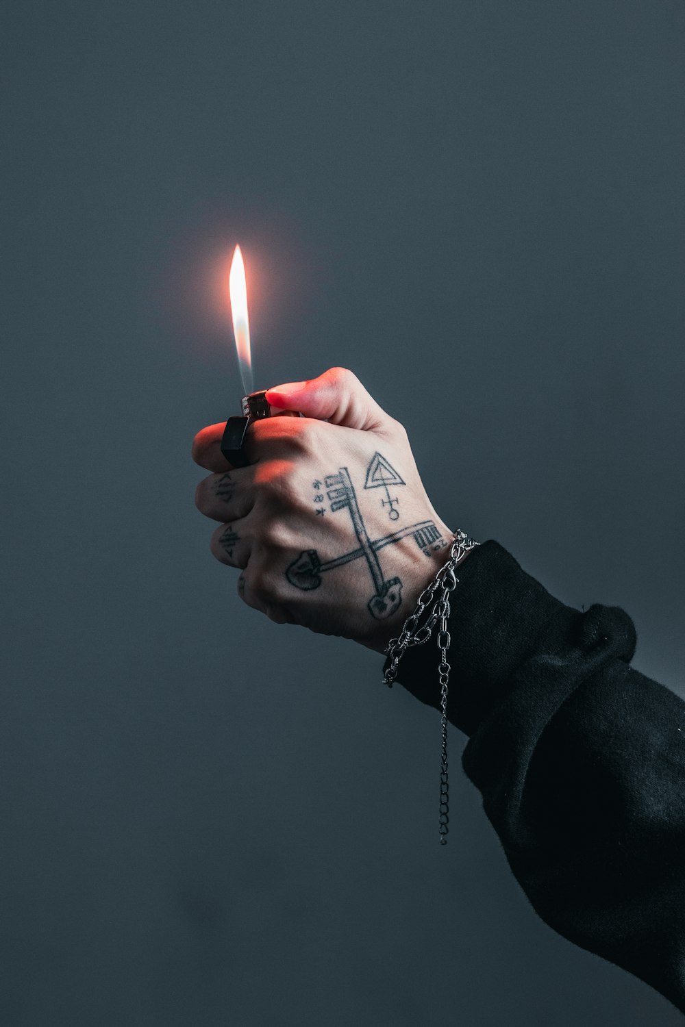 a hand holding a lit candle