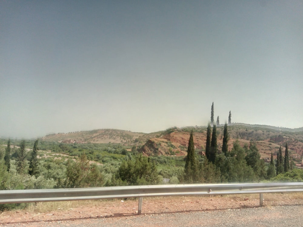 a road with trees and hills in the background