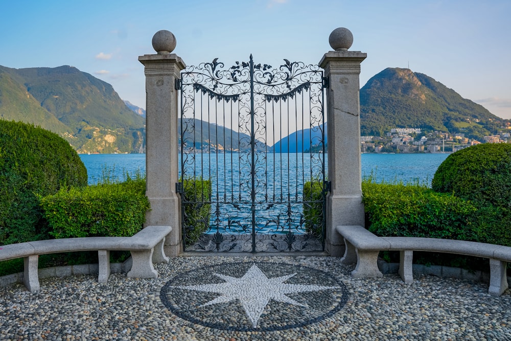 a gate with a view of a city and mountains in the background