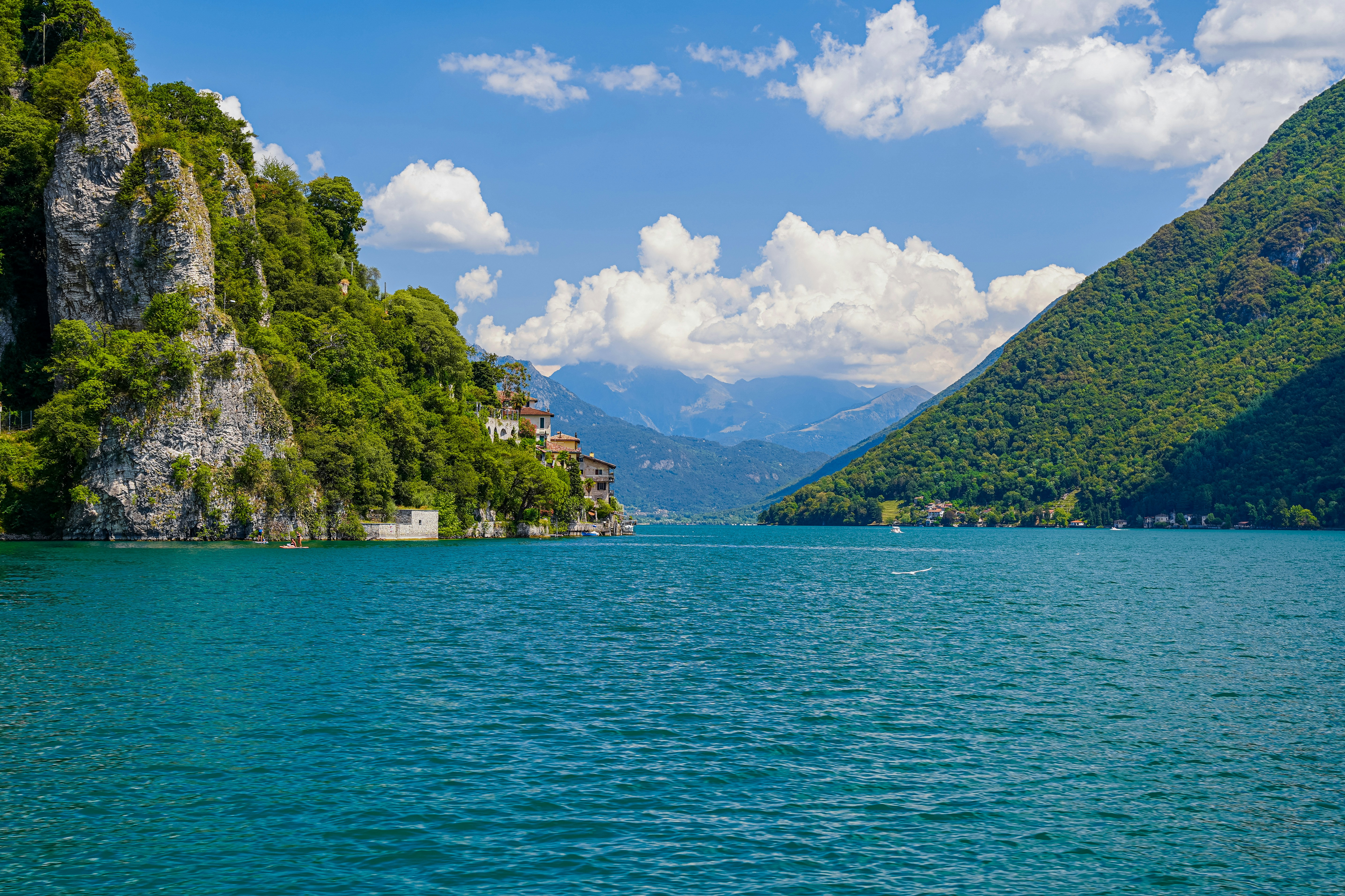 a body of water with trees and mountains around it