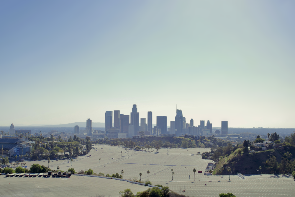 a city skyline with trees and water