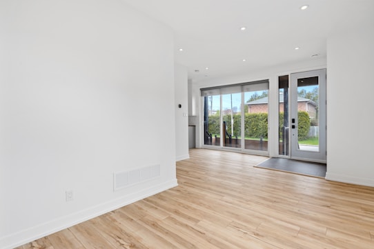 a room with a wood floor and windows