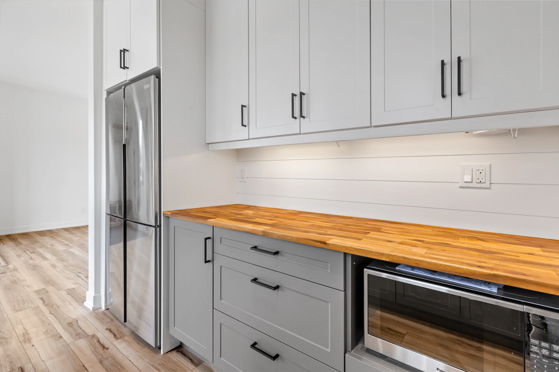 Kitchen with custom white cabinetry and butcher block counter