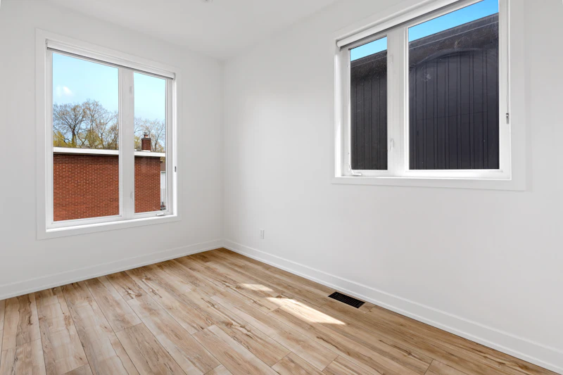 Heller Wohnraum mit durchgehendem Designboden in Holzoptik und großen Fenstern