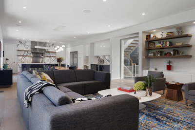Spacious living room floor covered with large dark gray porcelain tiles reflecting natural light.