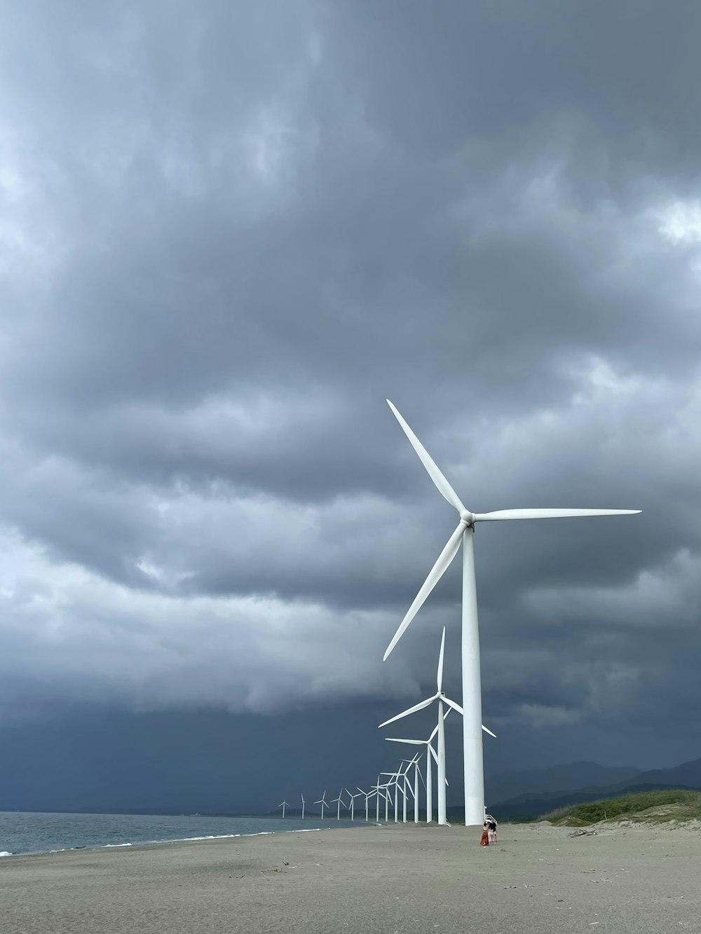 a group of wind turbines on a beach