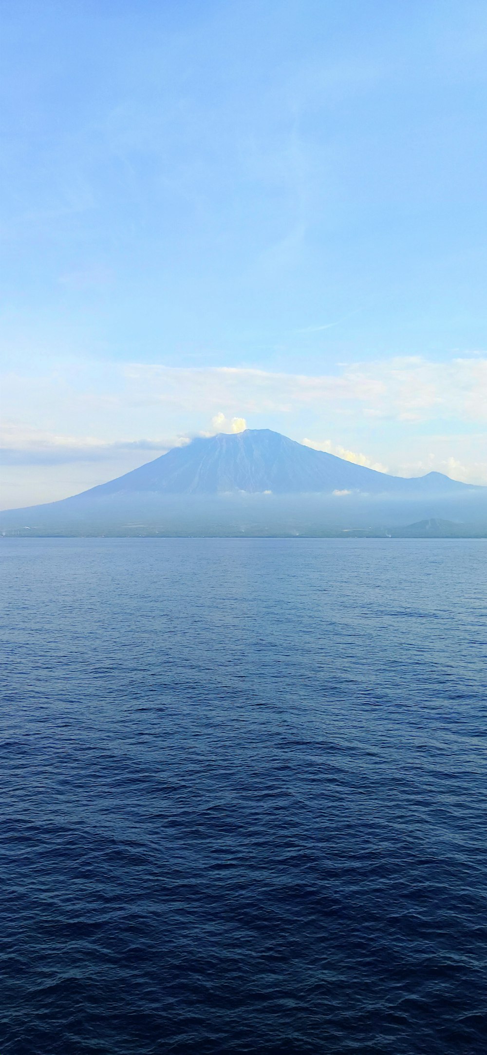 a body of water with a mountain in the background