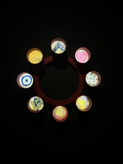 Series of small, unique pointillist wood panels arranged together, highlighting individuality.